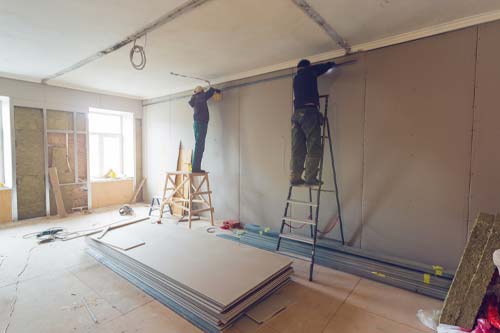 2 team members restoring a room walling